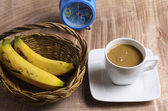Une tasse de café et un panier de bananes.