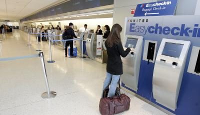 Femme utilisant les États-EasyCheck-Kiosk à l'aéroport international JFK, NY.