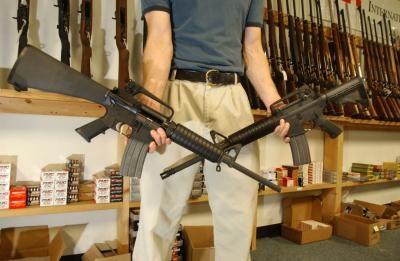 Homme tenant deux Colt's AR-15's