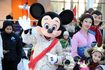 Enfants debout avec Mickey Mouse et la princesse Mulan à Disney World.