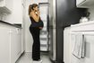 Une femme enceinte regardant dans le réfrigérateur.