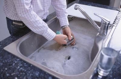 Man plats à laver dans un évier de cuisine.