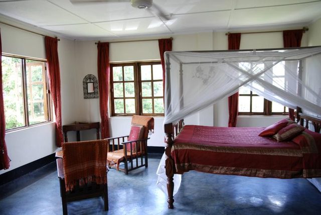 Moustiquaire soigneusement drapé autour d'un lit à baldaquin dans une chambre de plantation.