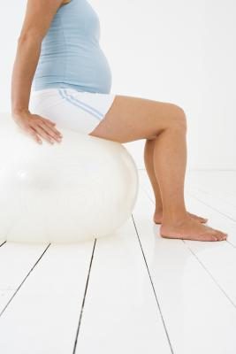 Une femme enceinte sur ballon d'exercice