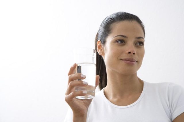 Close-up de la femme tenant un verre d'eau.