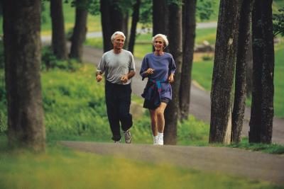 Couple d'âge mûr jogging dans les bois.