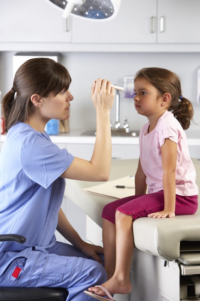 Médecin examine l'enfant's eyes