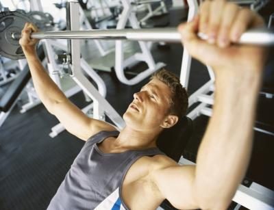 Un homme soulève des poids à la salle de gym.