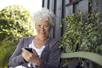 Une femme utilise son téléphone intelligent dans la cour.
