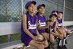 Groupe de jeunes filles assises sur softball banc.