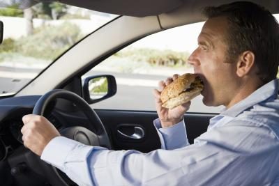 homme manger fast-food dans sa voiture