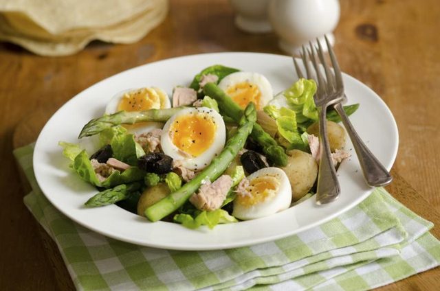 Salade de thon dans un bol avec les asperges, pommes de terre, olives et des œufs durs.