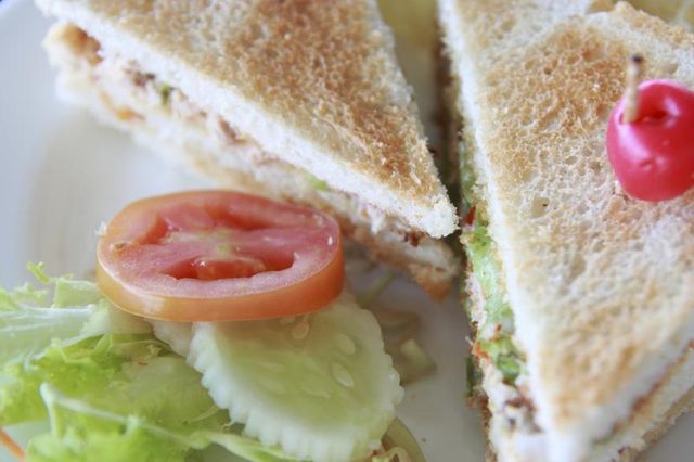 Un sandwich salade de fruits de mer servis sur un toast avec du concombre frais, la tomate et la laitue.