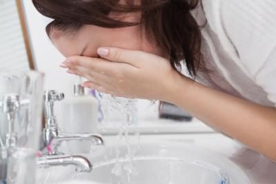 Femme lavant son visage avec de l'eau