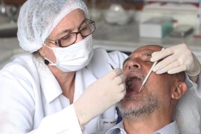 Un hygenist dentaire nettoie un homme's teeth during a routine check-up.