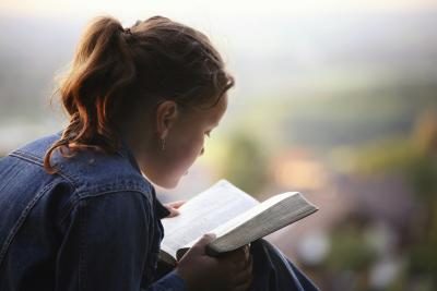 Jeune femme lisant la Bible.