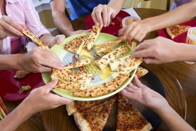 Groupe d'amis partageant la pizza