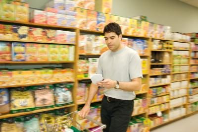 Un homme regarde sa liste d'achats dans un magasin d'aliments naturels.