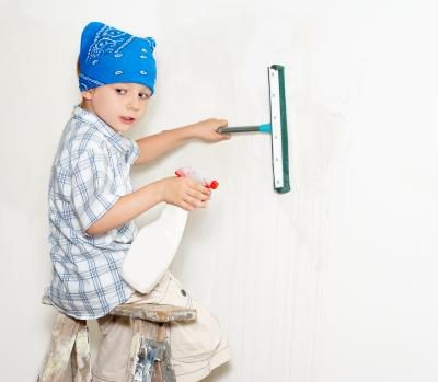 Jeune garçon lavage d'un mur.