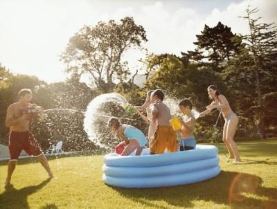 Famille jouant dans la piscine gonflable pendant l'été.