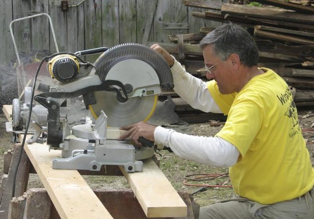Un bénévole de couper du bois sur un chantier de construction.