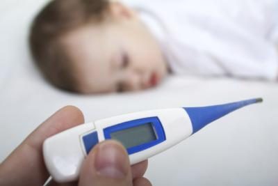 Thermomètre avec bébé malade en arrière-plan