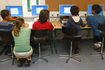 Un enseignant aide les étudiants dans un laboratoire d'informatique à l'école.