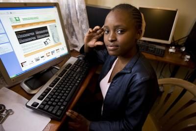Une adolescente ouvre une page Web à un bureau.