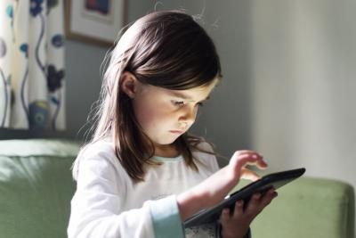 Un enfant utilise une application logicielle sur un ordinateur tablette.