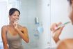 femme se brosser les dents dans salle de bain