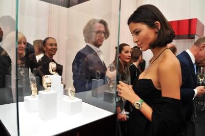 Jeune femme admire montres Cartier en cas d'affichage