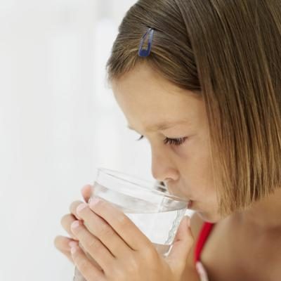 Une jeune fille boire de l'eau tout en se sentant malade.